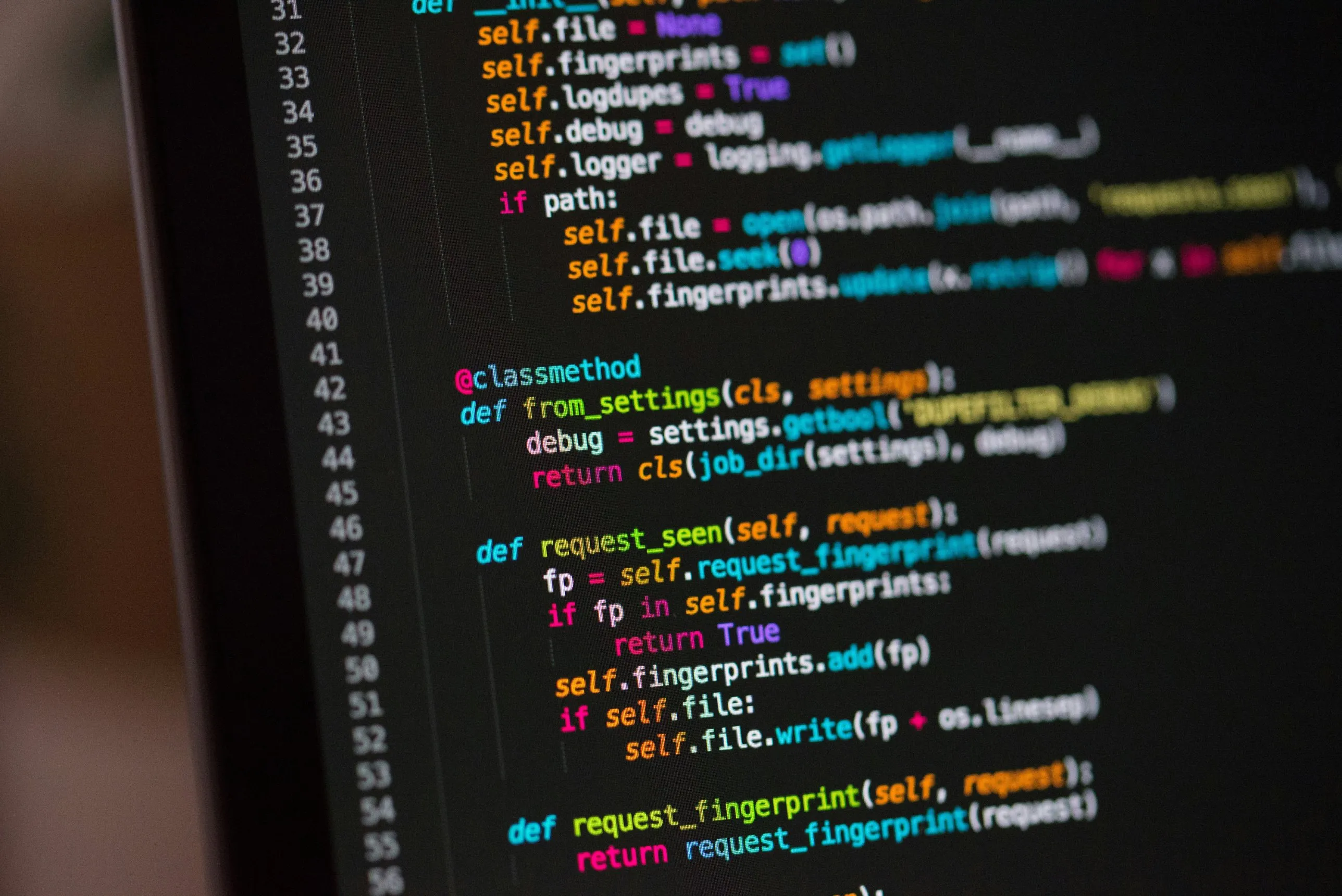 Close-up of a code editor on a dark screen, showing colorful lines of Python code.
